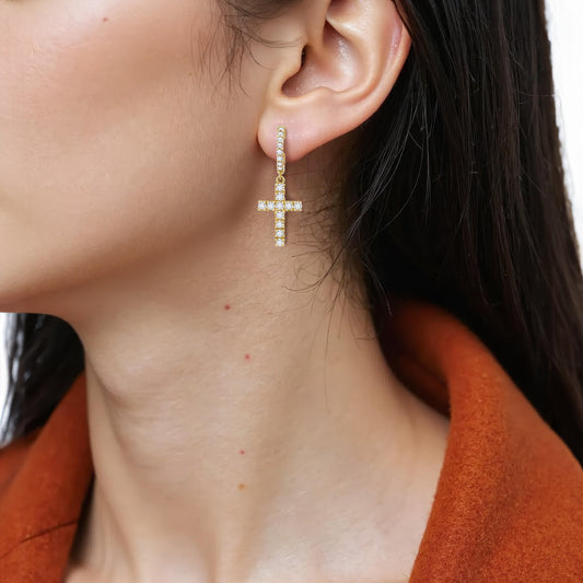 Close-up of a person wearing 14K Yellow Gold Sparkle Cross Hoop Earrings with Lab-Grown Diamonds